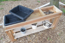 Load image into Gallery viewer, Wooden 3-bin sensory table with rubber buckets. The bottom shelf features several metal bins not included with the product. 
