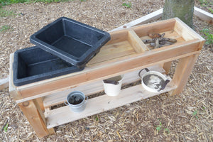 Wooden 3-bin sensory table with rubber buckets. The bottom shelf features several metal bins not included with the product. 